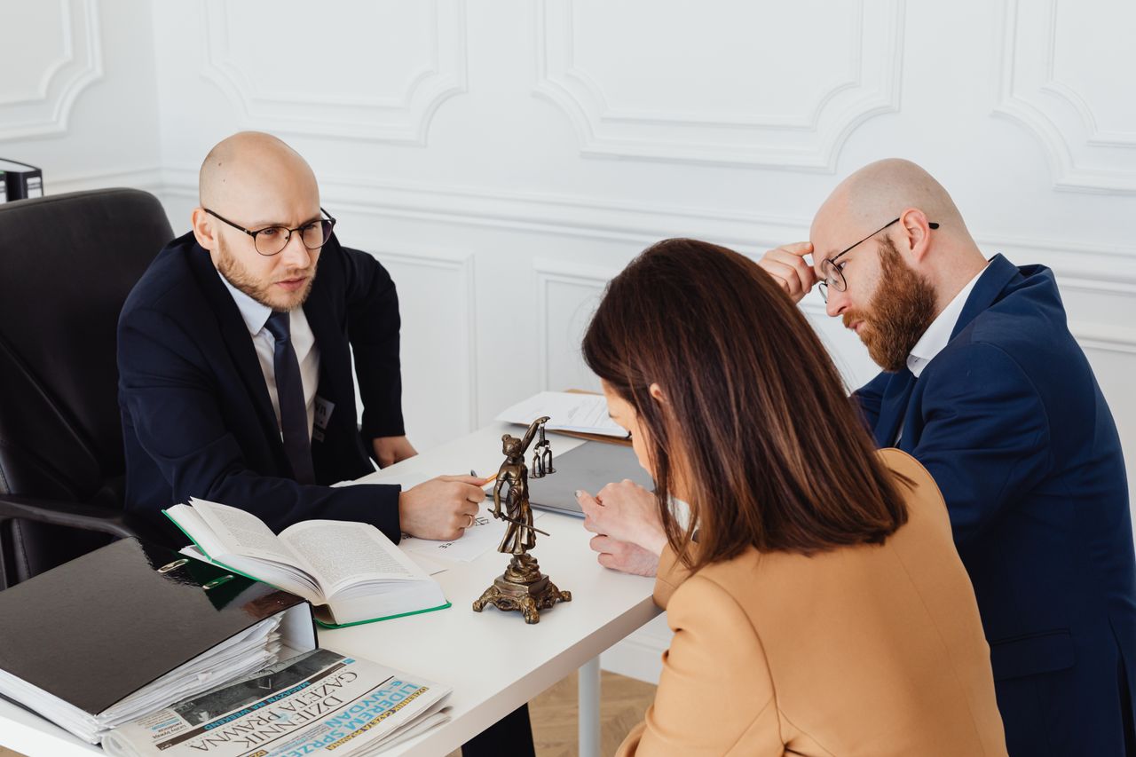 Services Lawyer consulting clients in a modern office setting, serious discussion.